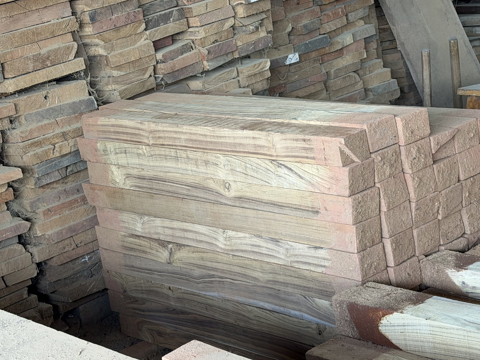 Stacked teak planks showing rich grain